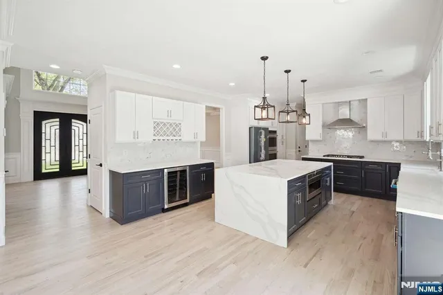 a kitchen with stainless steel appliances granite countertop a stove top oven a sink dishwasher and a refrigerator with wooden floor