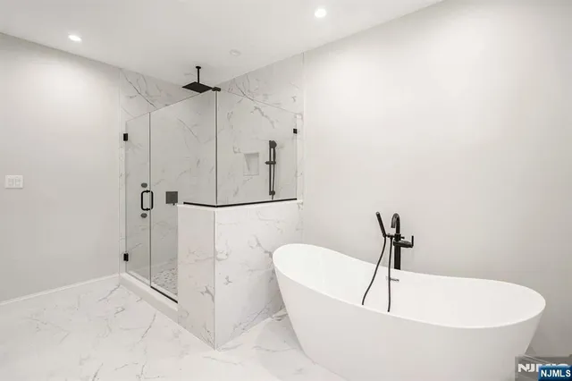 a white bath tub sitting next to a shower