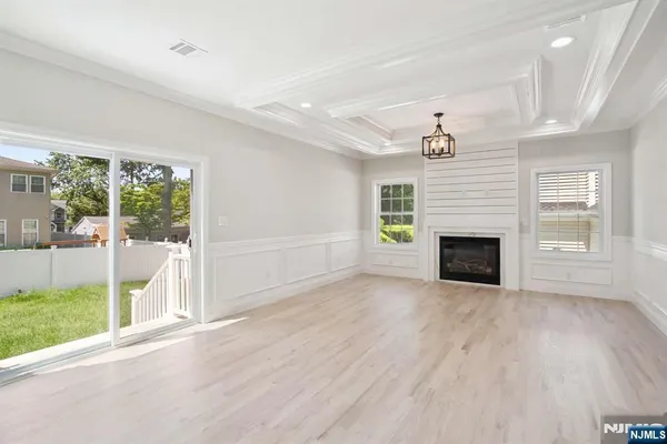 a view of empty room with wooden floor and fireplace