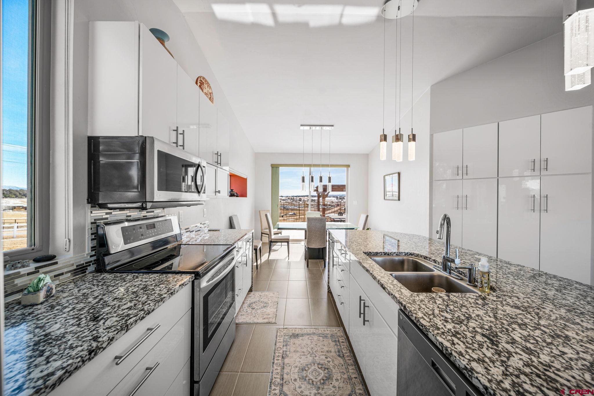 59 Chesterfield Place Ignacio, CO 81137 - Photo 13 of 35 a kitchen with stainless steel appliances kitchen island granite countertop a sink stove and refrigerator