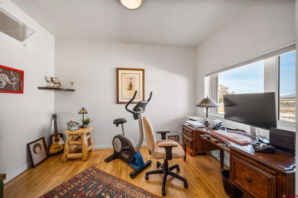 a view of a workspace with furniture and a window