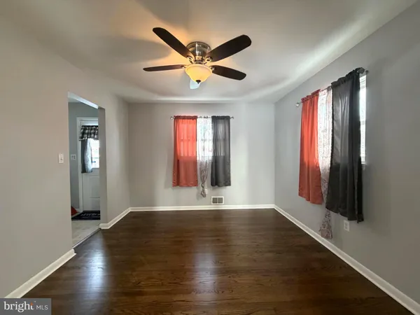 a view of an empty room with window and wooden floor