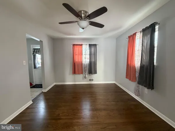 a view of an empty room with window and wooden floor