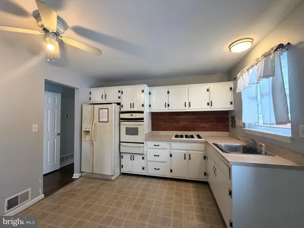 a kitchen with stainless steel appliances a stove a sink and a refrigerator