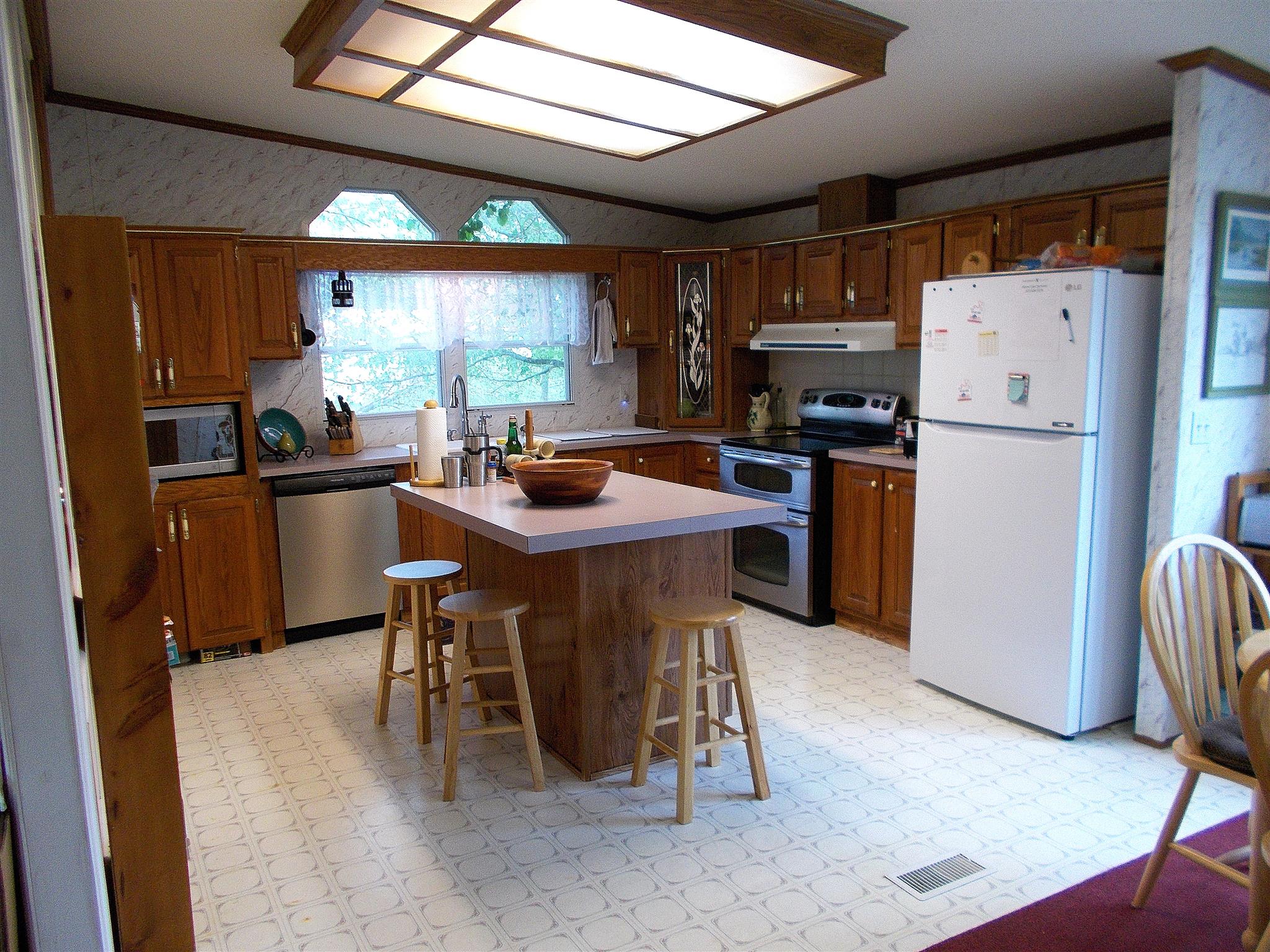 179 Duke Road Dickson, TN 37055 - Photo 8 of 30 a kitchen with stainless steel appliances kitchen island granite countertop a table chairs and a refrigerator