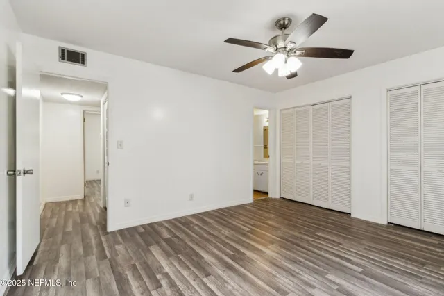 wooden floor in an empty room with a fan