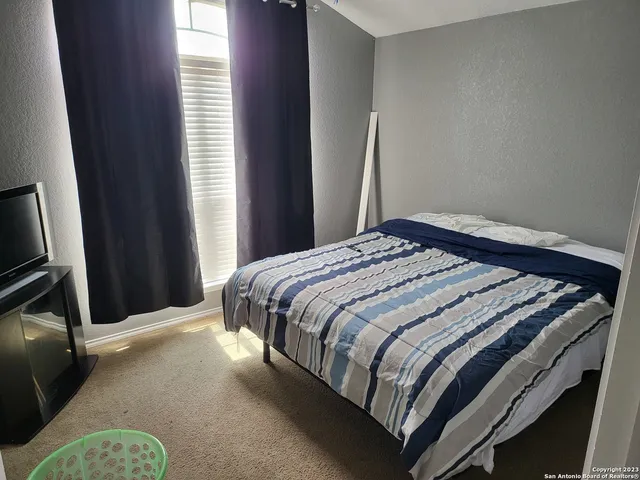 a bed sitting in a bedroom next to a window