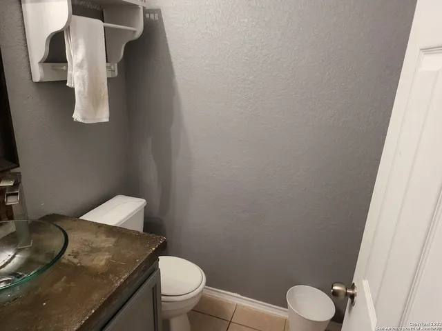 a bathroom with a granite countertop toilet and sink