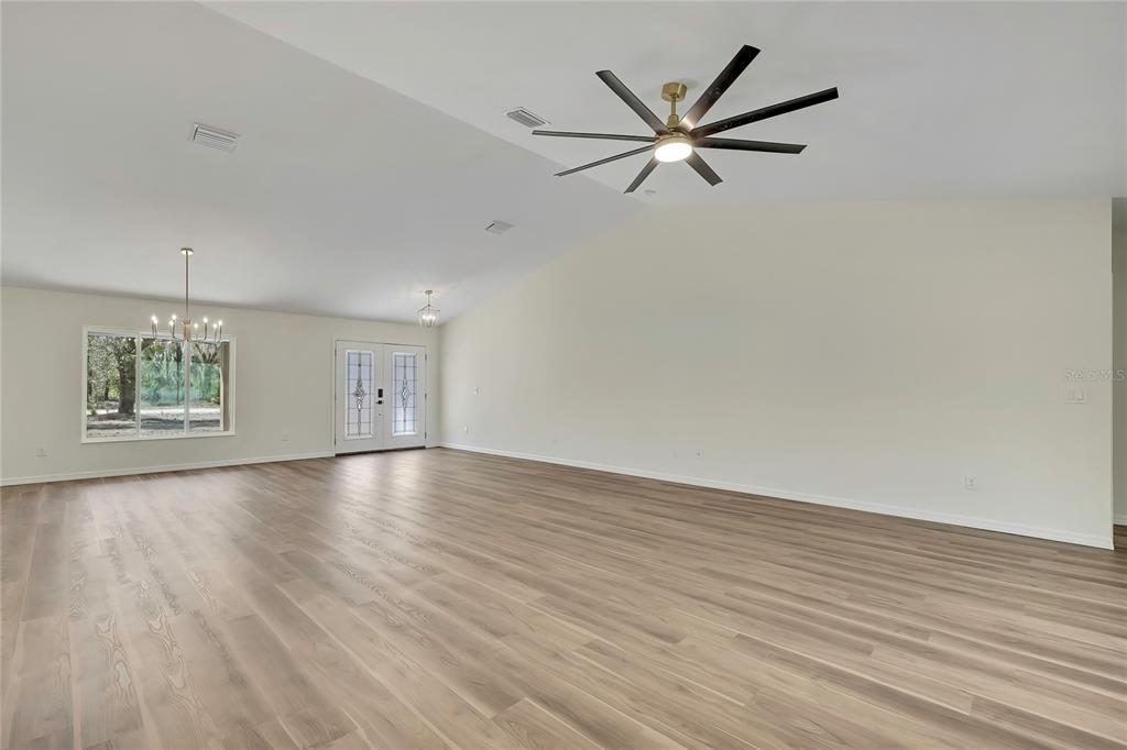 11929 West Cornflower Drive Crystal River, FL 34428 - Photo 16 of 50 an empty room with wooden floor ceiling fan and windows