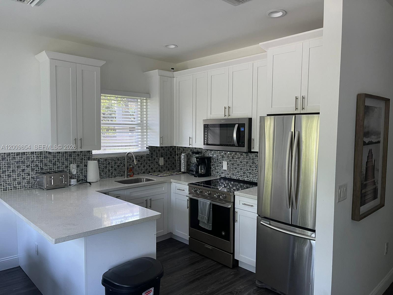 4034 Northwest 23rd Avenue Miami, FL 33142 - Photo 7 of 10 a kitchen with a refrigerator sink and stove