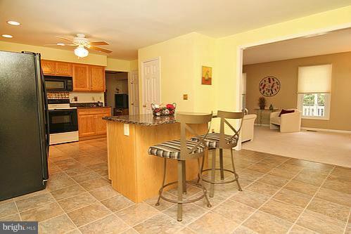 897 Bear Branch Road Westminster, MD 21157 - Photo 4 of 24 a kitchen with stainless steel appliances kitchen island granite countertop a table chairs and a refrigerator