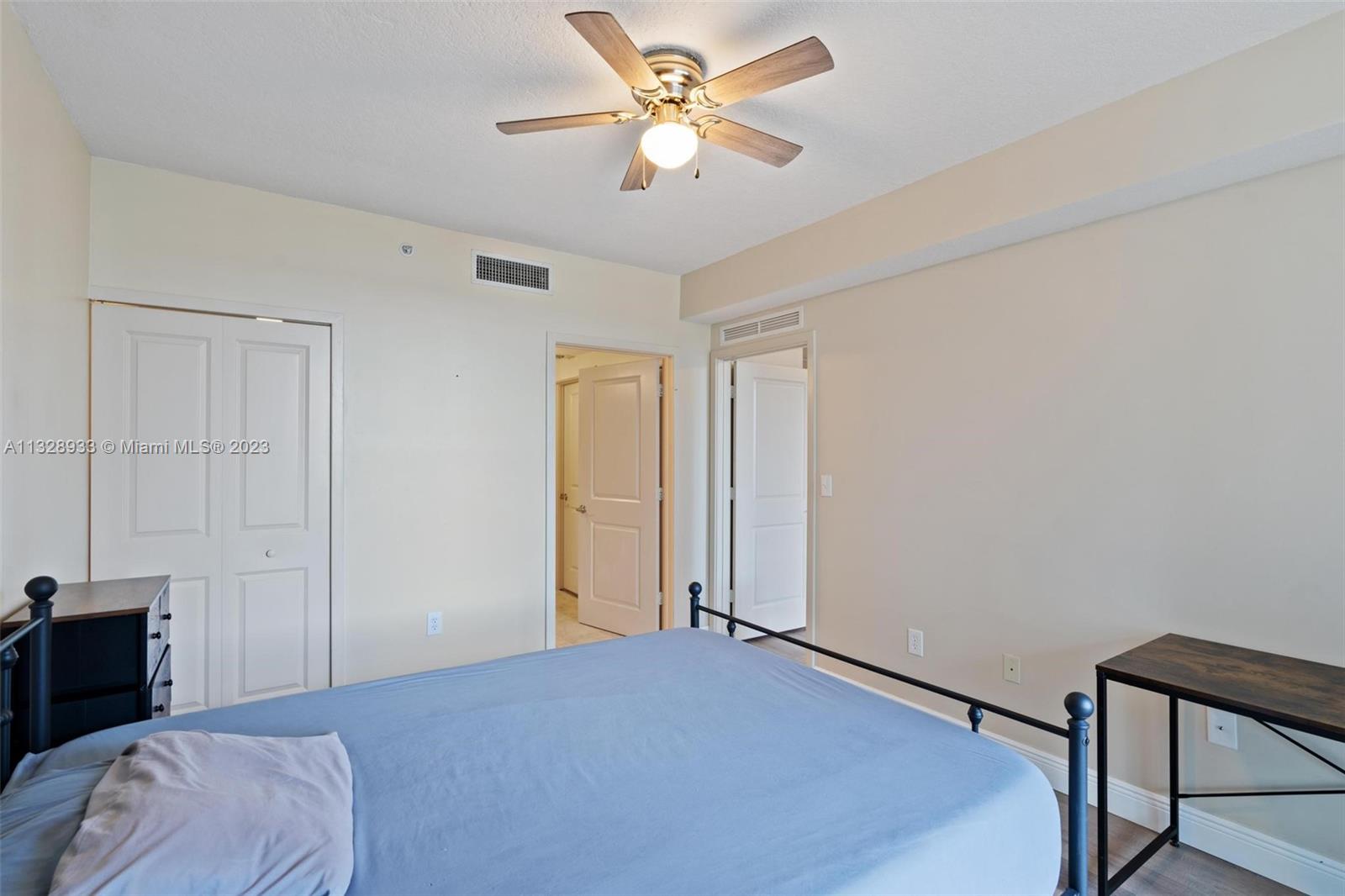 170 Southeast 14th Street, Unit 1906 Miami, FL 33131 - Photo 21 of 26 a bedroom with a bed and a chandelier