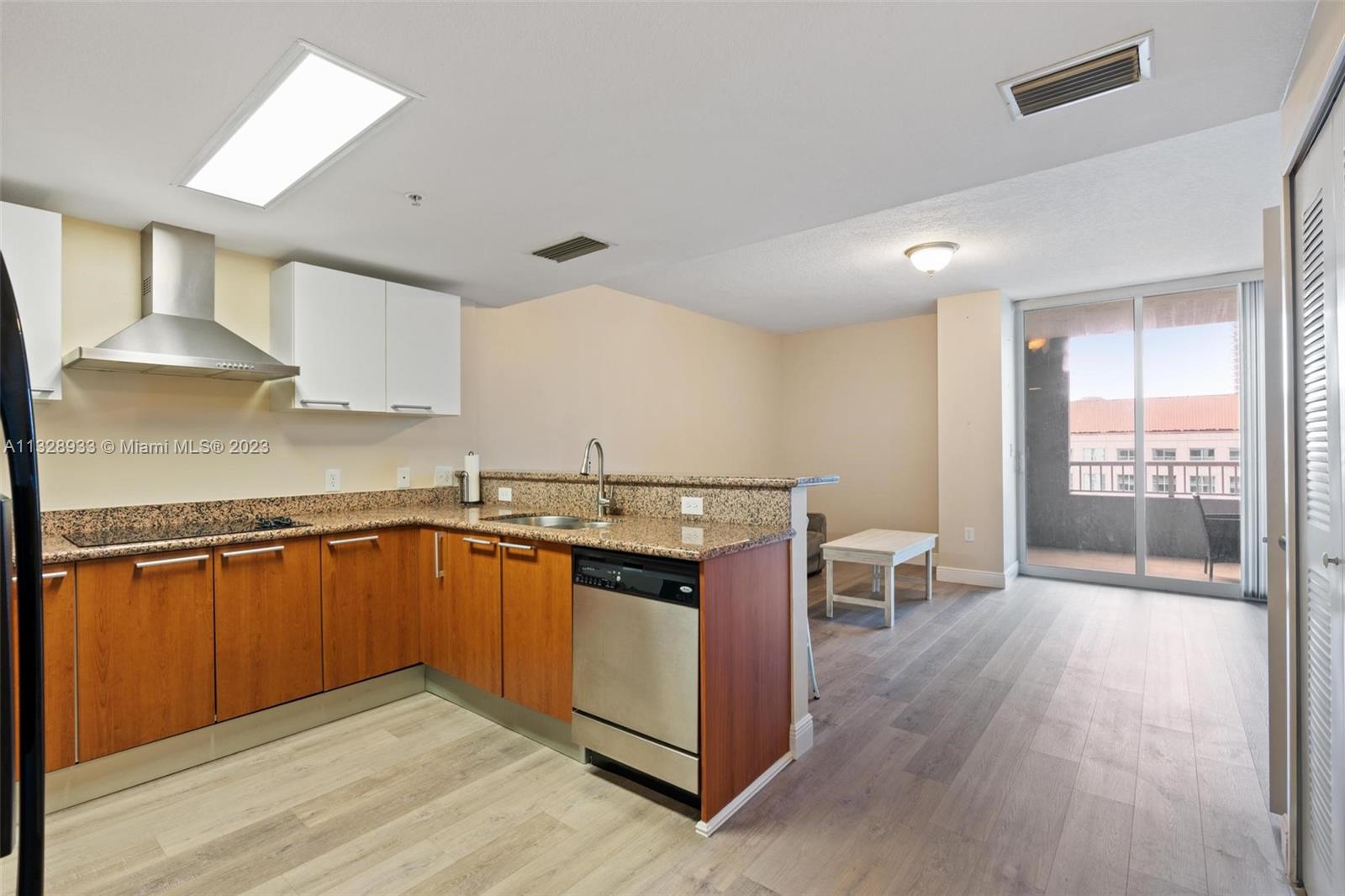 170 Southeast 14th Street, Unit 1906 Miami, FL 33131 - Photo 9 of 26 a kitchen with granite countertop a sink cabinets and wooden floor