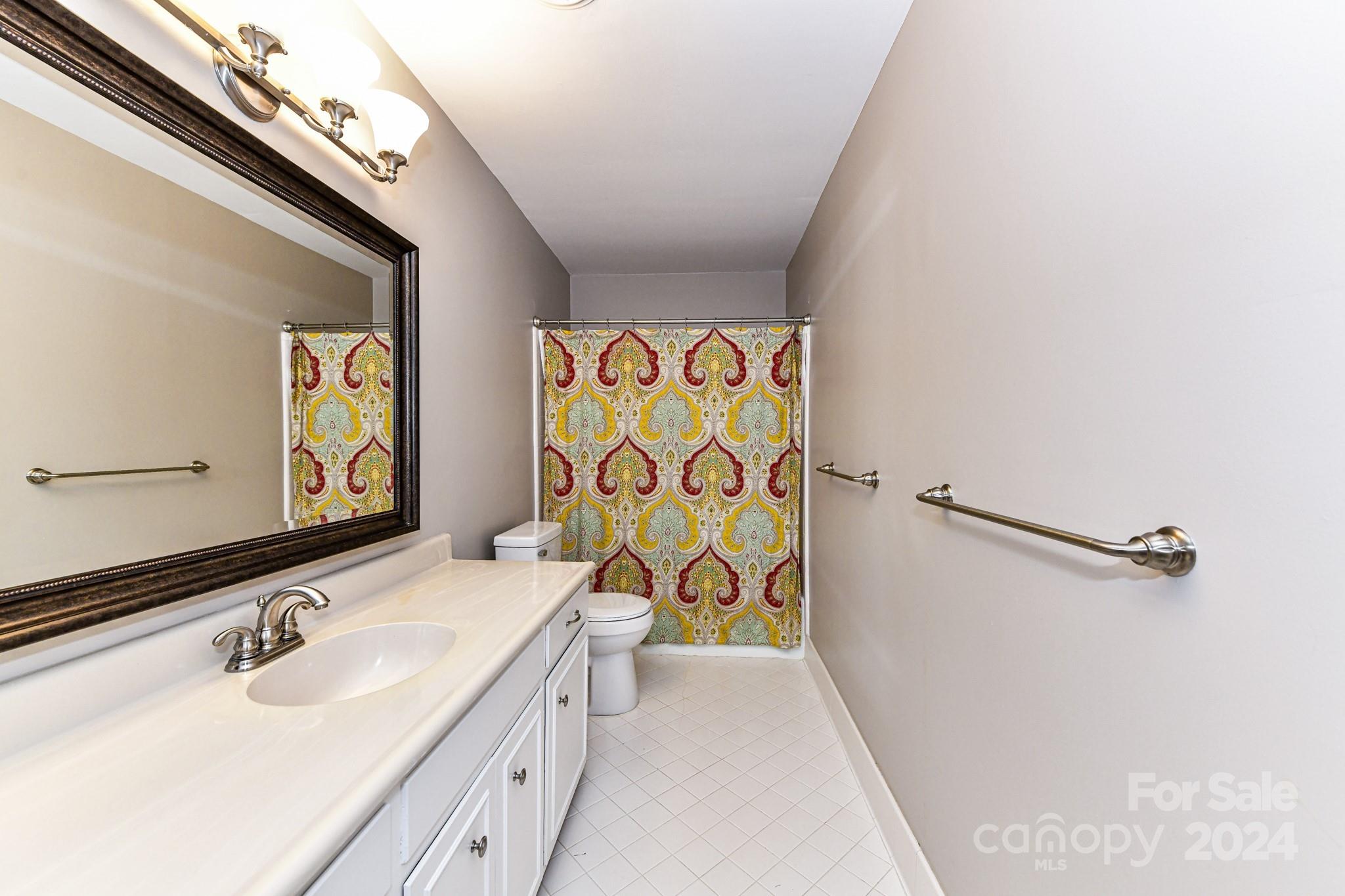 3026 Rustic Lane Charlotte, NC 28210 - Photo 31 of 39 a bathroom with a sink a vanity and a mirror