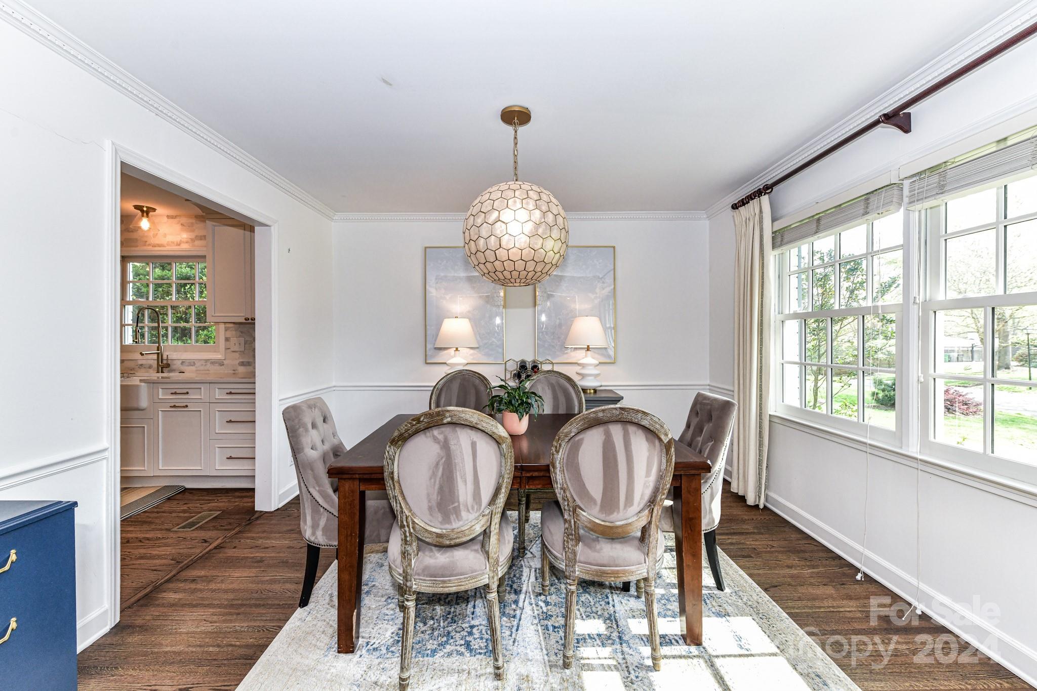 3026 Rustic Lane Charlotte, NC 28210 - Photo 7 of 39 a view of a dining room with furniture a chandelier and wooden floor