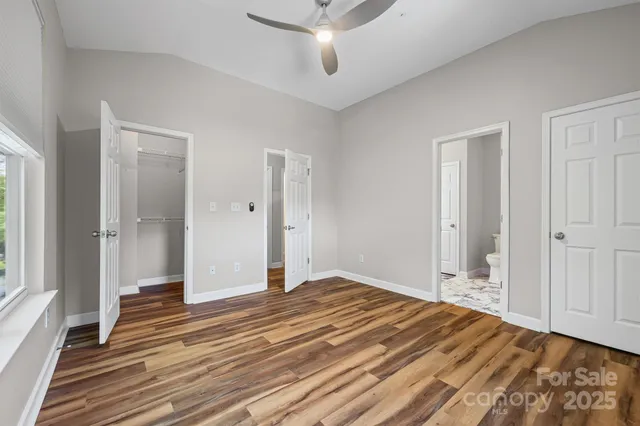 a view of a bedroom with wooden floor