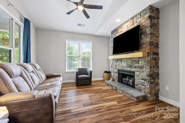a living room with furniture a flat screen tv and a fireplace