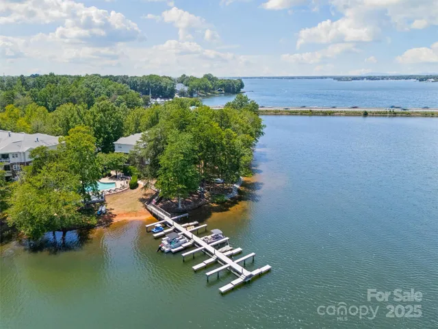 an aerial view of ocean and residential houses with outdoor space