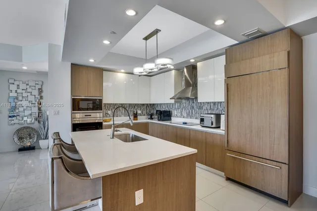 a kitchen with a sink a counter top space stainless steel appliances and cabinets