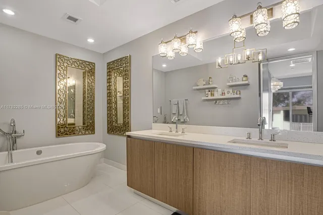a bathroom with a double vanity sink toilet mirror and bathtub