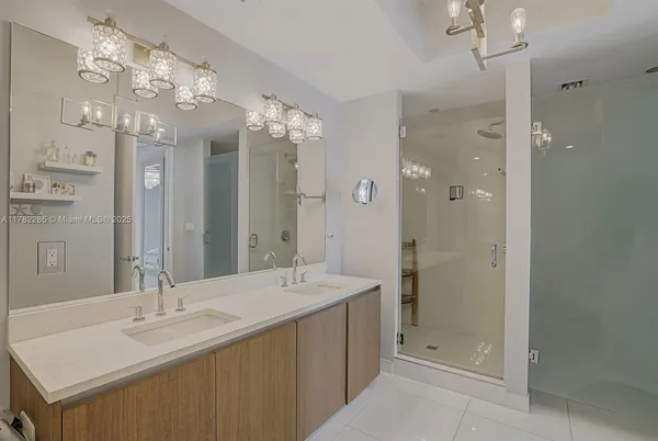a bathroom with a double vanity sink mirror and shower