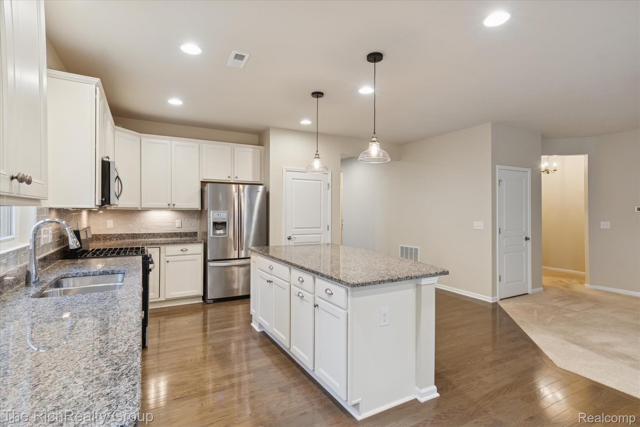 49534 Mapleton Road Canton, MI 48188 - Photo 14 of 37 Kitchen with backsplash, light stone countertops, appliances with stainless steel finishes, pendant lighting, and white cabinetry