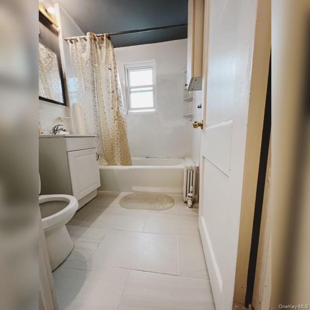 80-41 159th Street Queens, NY 11366 - Photo 12 of 13 Bathroom with shower / bathtub combination with curtain, vanity, light tile patterned floors, and radiator