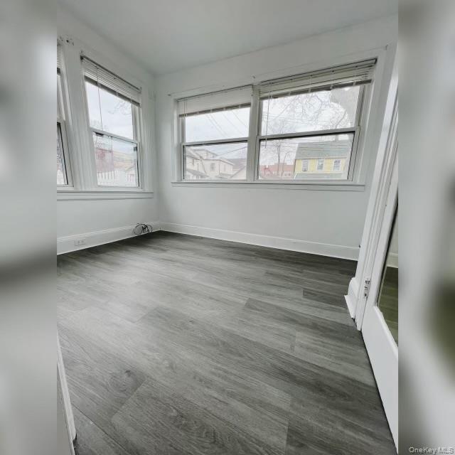 80-41 159th Street Queens, NY 11366 - Photo 6 of 13 Unfurnished bedroom with dark wood-style floors and baseboards