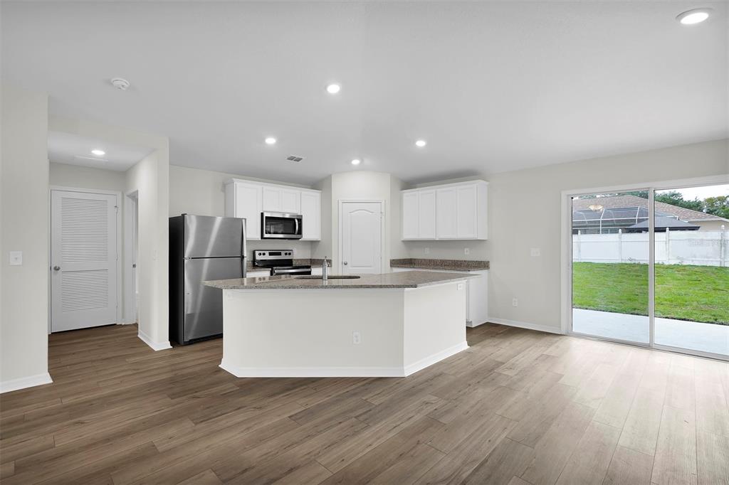 15605 Southwest 49th Avenue Road Ocala, FL 34473 - Photo 2 of 15 a kitchen with stainless steel appliances granite countertop a refrigerator and a stove top oven