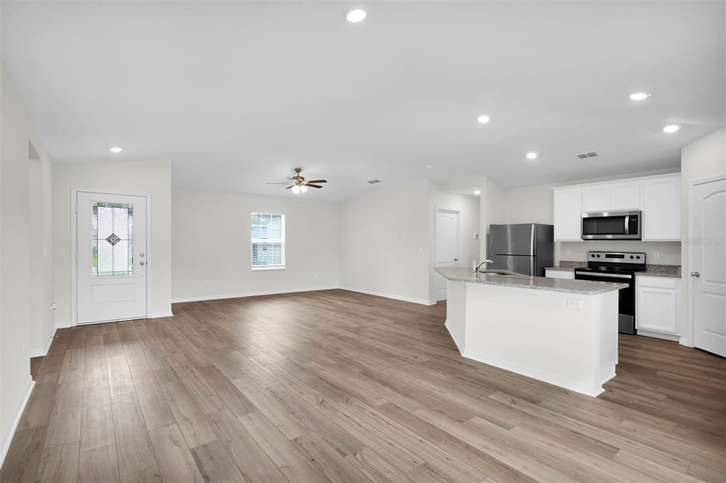 15605 Southwest 49th Avenue Road Ocala, FL 34473 - Photo 4 of 15 a view of kitchen with microwave a refrigerator and wooden floor