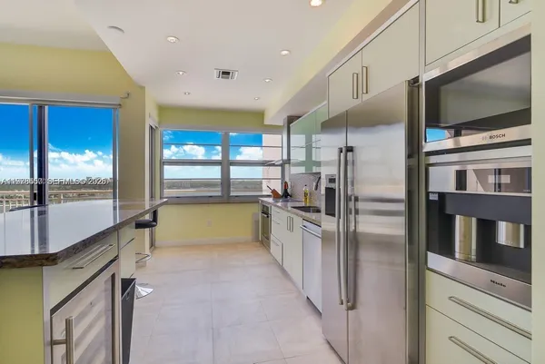 a kitchen with stainless steel appliances granite countertop a refrigerator and a sink