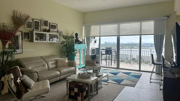 a living room with furniture and a floor to ceiling window