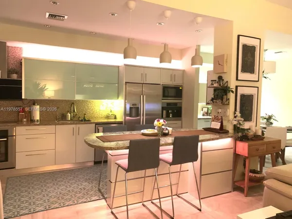 a kitchen with stainless steel appliances kitchen island granite countertop a sink and cabinets