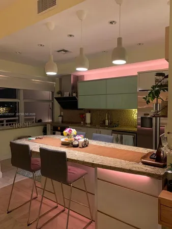 a living room with furniture kitchen view and a large window