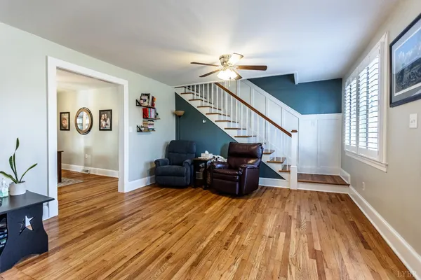 a living room with furniture ceiling fan and a window