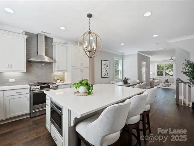 a kitchen with sink a stove dining table and chairs