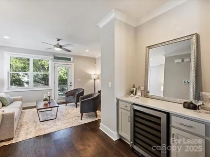 a living room with furniture a large window and wooden floor