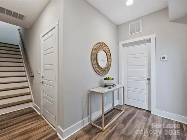 a view of a hallway with entryway wooden floor and front door