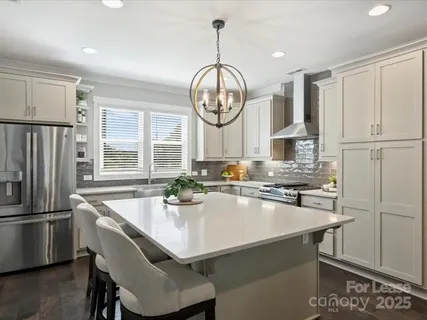 a kitchen with granite countertop a stove a refrigerator and a sink