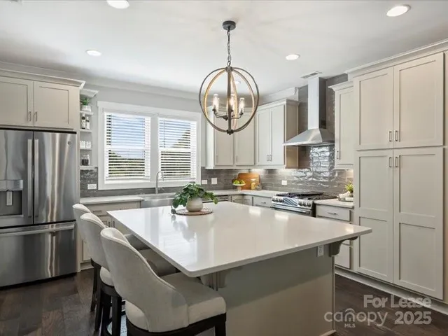 a kitchen with granite countertop a stove a refrigerator and a sink