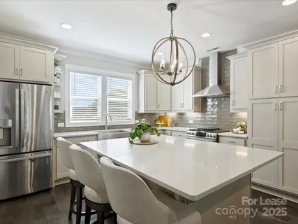 a kitchen with stainless steel appliances a table chairs and a chandelier