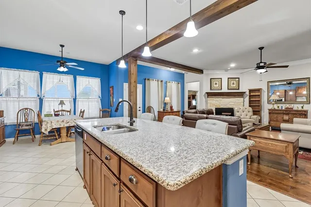 a large kitchen with kitchen island a stove a sink a dining table and chairs
