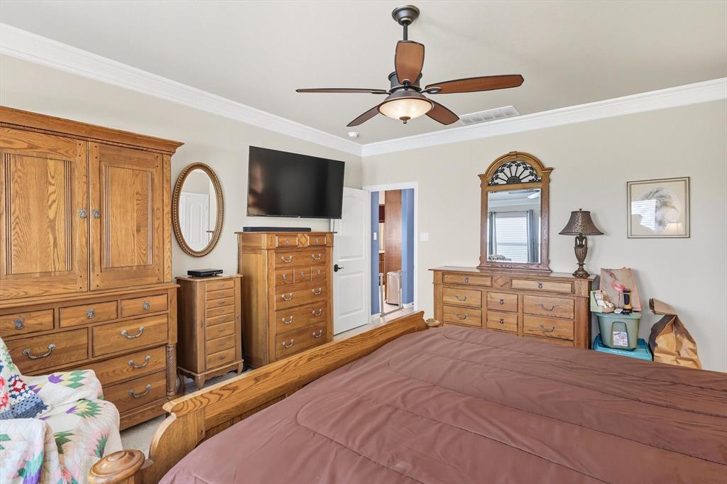 142 High Ridge Court Decatur, TX 76234 - Photo 14 of 40 a bedroom with a bed a mirror on dresser and a chandelier