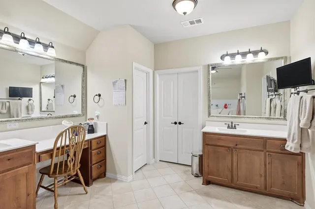a spacious bathroom with a double vanity sink and a mirror