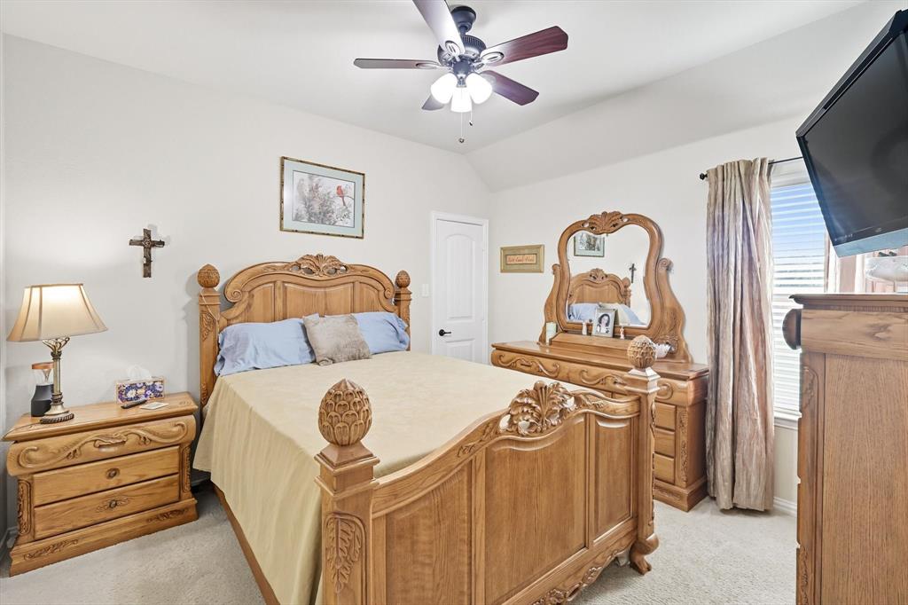 142 High Ridge Court Decatur, TX 76234 - Photo 22 of 40 a bedroom with a bed and a chandelier