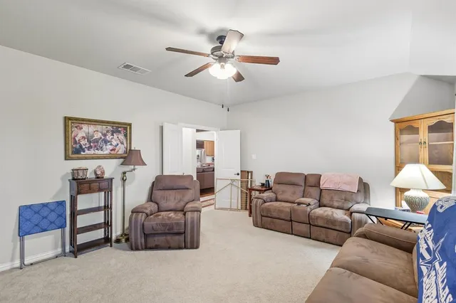 a living room with furniture and a ceiling fan