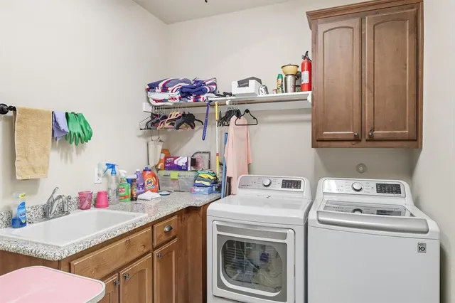 a utility room with sink dryer and washer