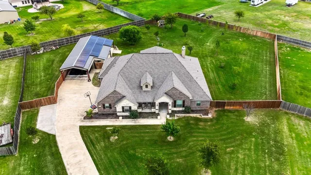 an aerial view of a house with swimming pool garden and patio