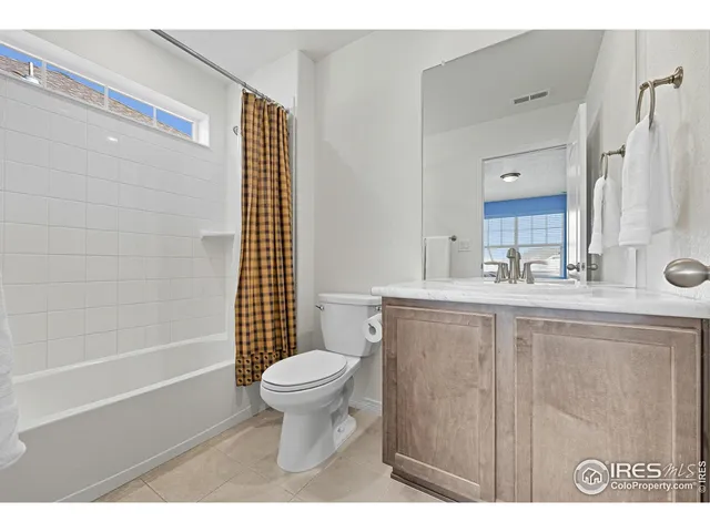 a bathroom with a granite countertop sink a toilet and a large mirror