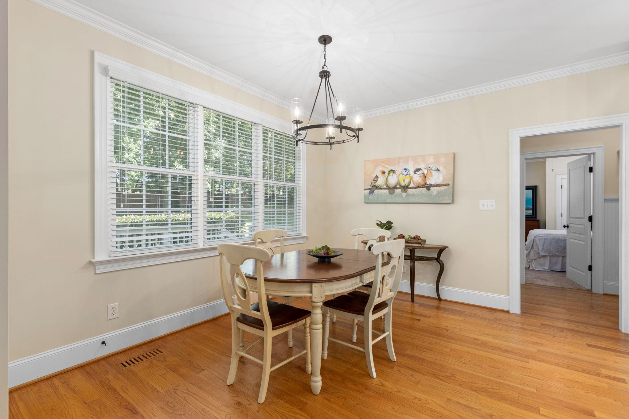 3720 Grandbridge Drive Apex, NC 27539 - Photo 22 of 81 a dining room with wooden floor a chandelier a glass table and chairs